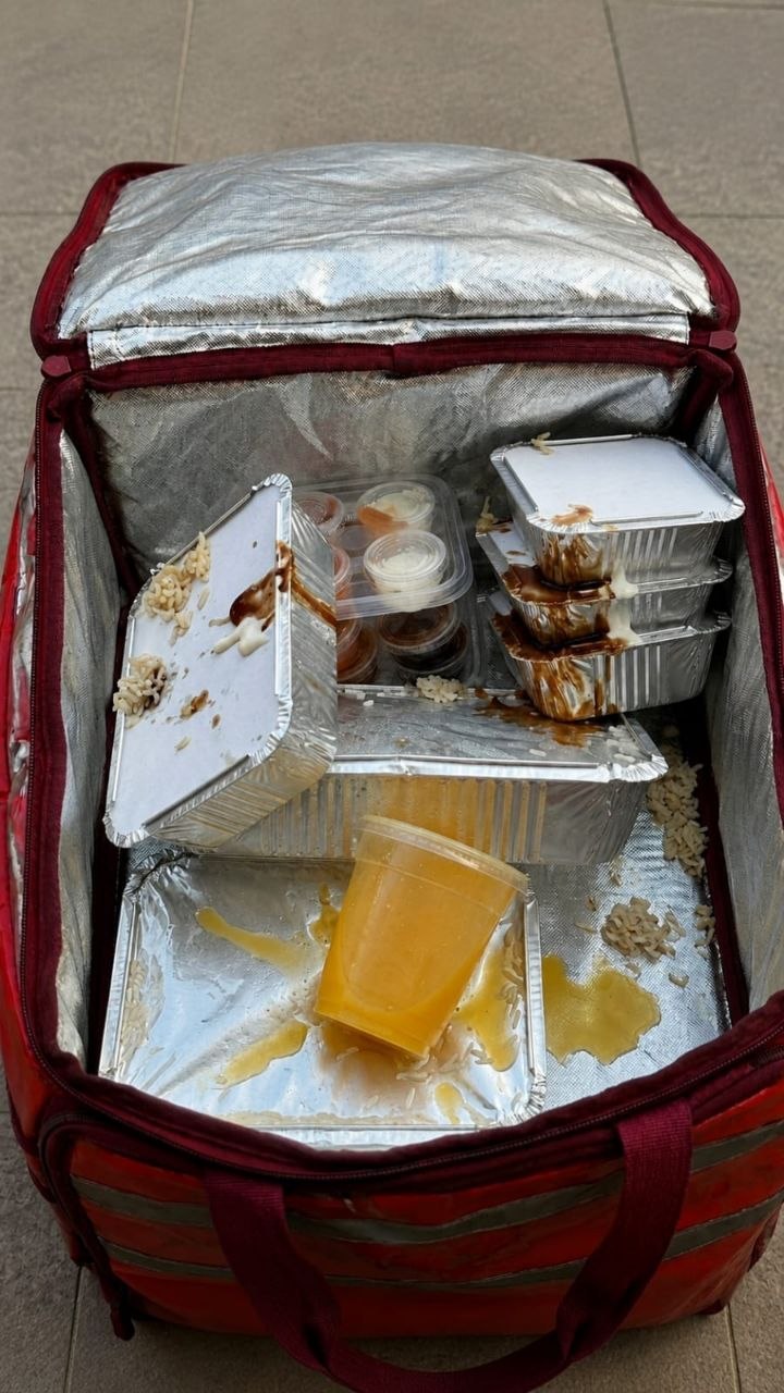 Open delivery bag interior showing unstable food container stacking and spills